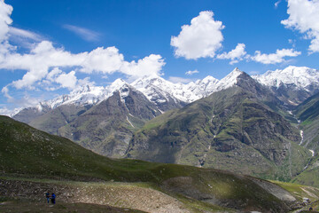 Fototapeta na wymiar Amazing view of spectacular snow covered himalayas enroute Rohtang Pass,Manali in Himachal pradesh. Beautiful view of snow capped high altitude mountain peaks.Blue skies with clouds and green meadows.