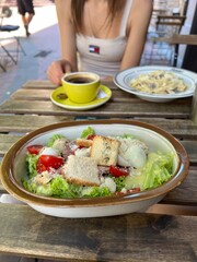 girl eats salad and spaghetti in a cafe