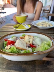 girl eats salad and spaghetti in a cafe