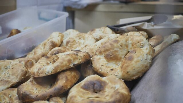 Bakers bake delicious national cakes with sesame seeds and sell them hot and soft right away. Fresh tasty bread baked in stone tonir. Georgia, Armenia, Azerbaijan