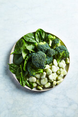 Raw green vegetables on a plate. Rich in calcium, kalium and vitamin K. Top view