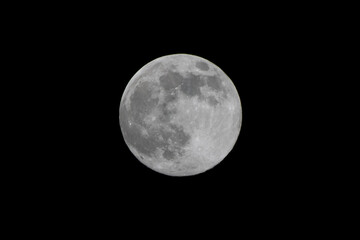 A white moon with clearly visible craters against a black night sky.