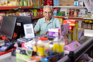 Happy man working as a cashier at supermarket