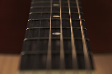 The neck of an acoustic six-string guitar. Macro.