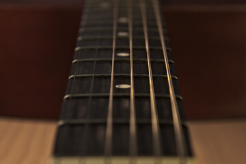 The neck of an acoustic six-string guitar. Close up.