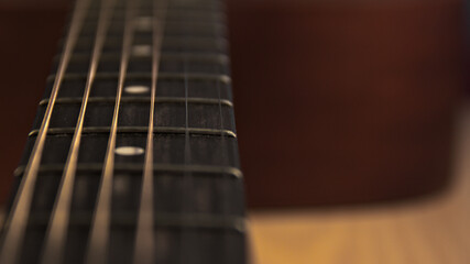 The neck of an acoustic six-string guitar. Place for text.