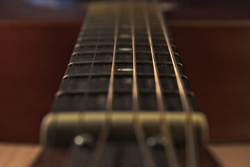 The neck of an acoustic six-string guitar. Close up.