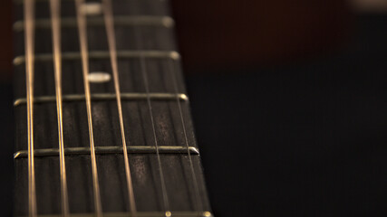 The neck of an acoustic six-string guitar. Place for text.