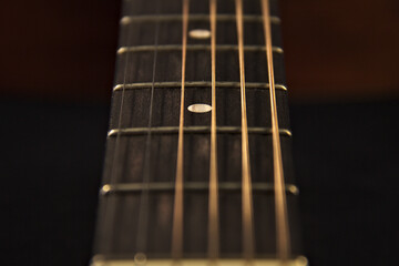The neck of an acoustic six-string guitar. Close up.