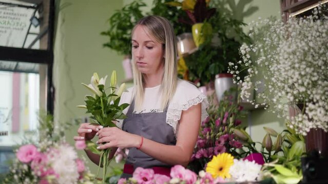 Floral artist working in flower shop. Floristry creating flower arrangement. Small woman business concept, self employed.
