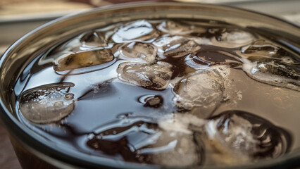 pieces of ice on the surface of the water in a mug close-up