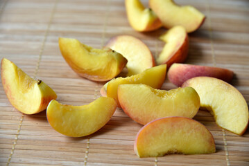 A lot of chopped apricot slices on the mat.