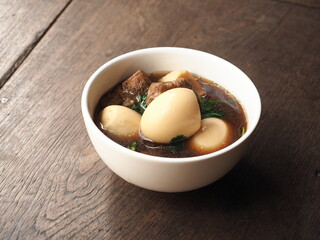 bowl of KAI PALO, braised five spice pork and egg stew,, on wooden table