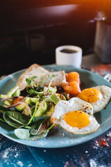 fresh breakfast with fried eggs, bread, avocado, red fish salmon and coffee