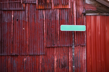 Red zink wall with green colour empty street plate