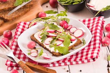 Rye bread with cottage cheese, radish and arugula.