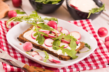 Rye bread with cottage cheese, radish and arugula.