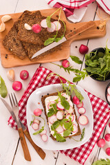 Rye bread with cottage cheese, radish and arugula.
