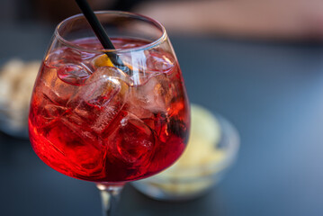 Refreshing Red Cocktail with Straw and Orange Peel