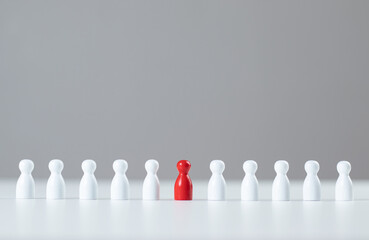 leadership concept Man's red puppet made of wood on gray background. stand out from the crowd...