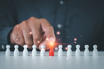 Businessman hand touching red wooden doll represents human resource management concept. recruiting talent Have high leadership to lead your business and organization to success.Teamwork. wooden block.