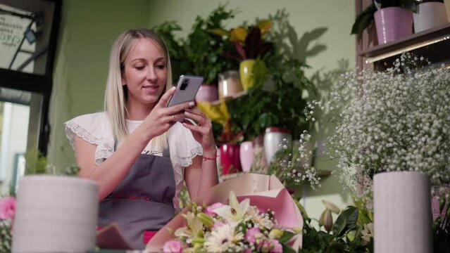 Florist Entrepreneur Using Smartphone For Photographing Plants At Her Flower Shop. Photographing Plants For Social Media