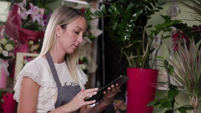 Close up of a young girl using a tablet while working in a flower shop