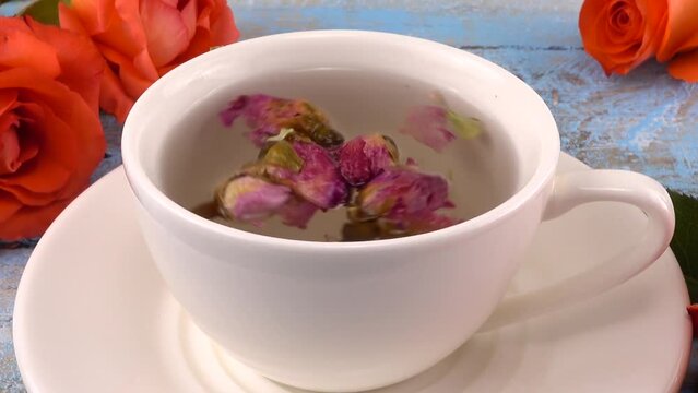 White cap of tea with fragrant dried rose buds, fresh