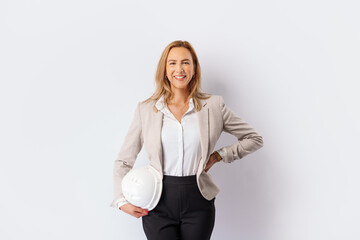  Smiling woman builder with a white safety helmet in hand