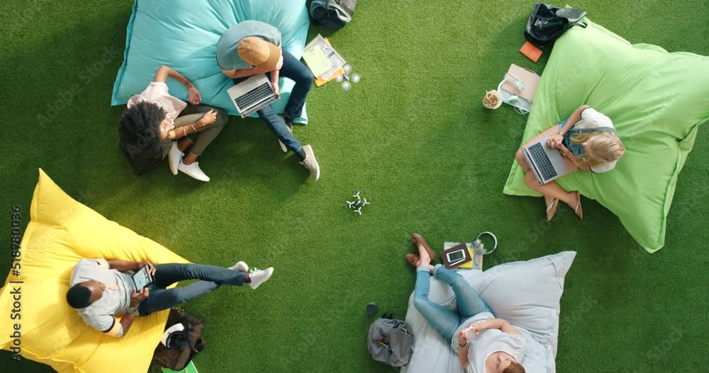 Poster diverse group of modern technology students using fun outdoor lounge to boost startup creativity. cr