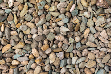 A close up view of decorative pastel-colored pebbles on a garden floor