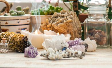 Cozy space with candles, crystals, herbs, and plants. Alternative medicine, herbal medicine, aromatherapy or esoteric background with incense smoke.
