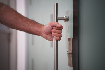 Male hand open the office glass door. Male hand open door knob. Man hand prepare to open the door to entering an office background