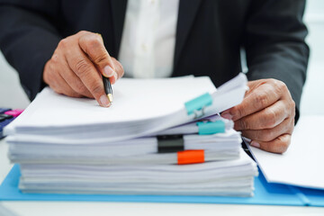 Businessman working and prepare paperwork report data to analysis information in file binder at...