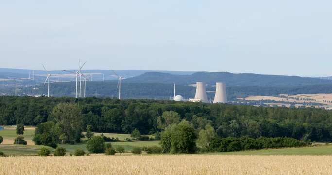 Grohnde, Germany - 07/12/2022; Nuclear power plant reactor and cooling towers. Embedded in landscape with trees, fields and forest.