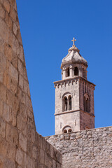 Fototapeta na wymiar Dominican church tower in Dubrovnik Old Town, Croatia, with city walls in forground.