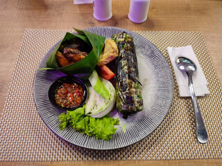 Grilled chicken and nasi bakar, seasoned rice covered with banana leaf and then grilled. 