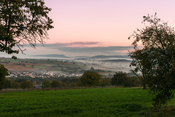 Fototapeta na wymiar Sunrise over rolling hills and pastures in Southern Germany