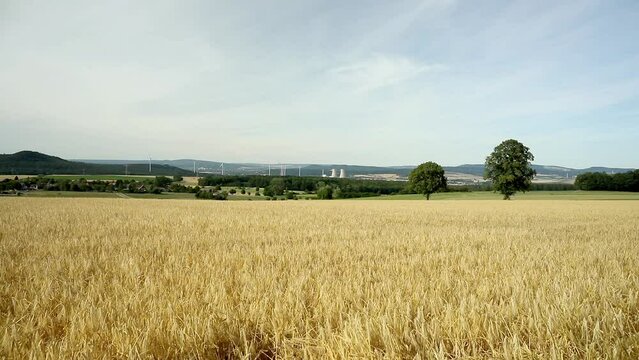 Grohnde, Germany - 07/12/2022; Nuclear power plant reactor and cooling towers. Embedded in landscape with trees, fields and forest.