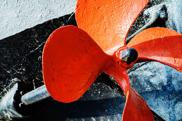 Large propeller of an old ship. Metal blades painted with red paint. Close-up