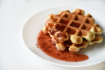 Viennese waffles with jam on a white plate. Delicious sweet breakfast with waffle.