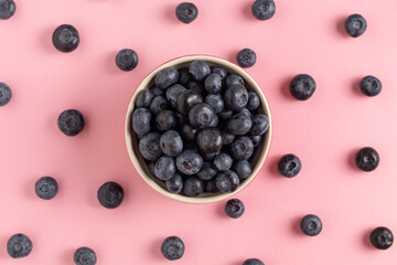 Ripe sweet blueberries on a pink background.