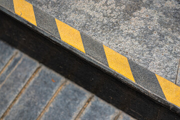 Anti-slip surface with caution strip line on the edge of different level floor. Close-up and...