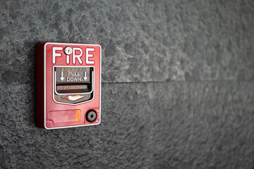 A fire alarm trigger box which is installed on building wall. Emergency and safety equipment object...