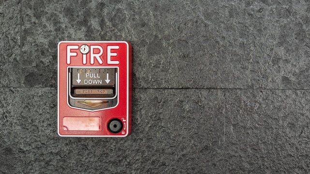 A fire alarm trigger box which is installed on building wall. Emergency and safety equipment object photo. Selective focus.