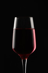 A close up on red wine glass on black background, contours light