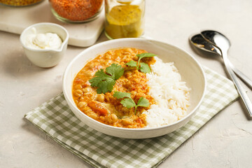 Indian red lentil curry with chickpeas, white rice and fresh cilantro - chana dal - in a white bowl...