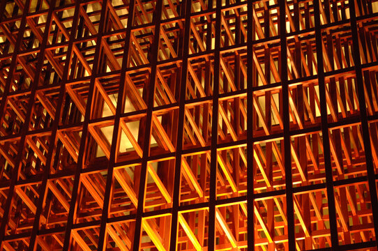 Illuminated wooden structure lit by orange and red lights and bearing Chinese characters
