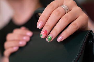 
Beautiful female hands with creative manicure nails, pink gel polish, tropical leaves design
