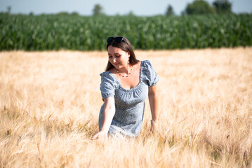Naklejka na ściany i meble Portrait of happy girl in wheat field, nature of Ukraine. Growing grains for agricultural aims.Summer time 